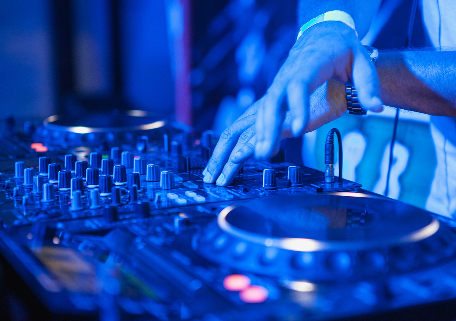 cq5dam 0001 dj playing music at mixer on colorful blurred back PAZNFQ5
